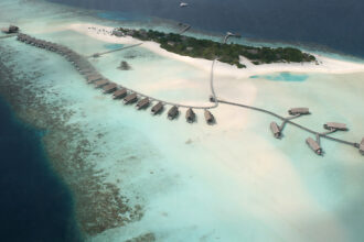 Small Maldivian island surrounded by a coral reef